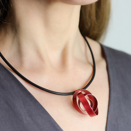 Red wide ribbon coil pendant worn