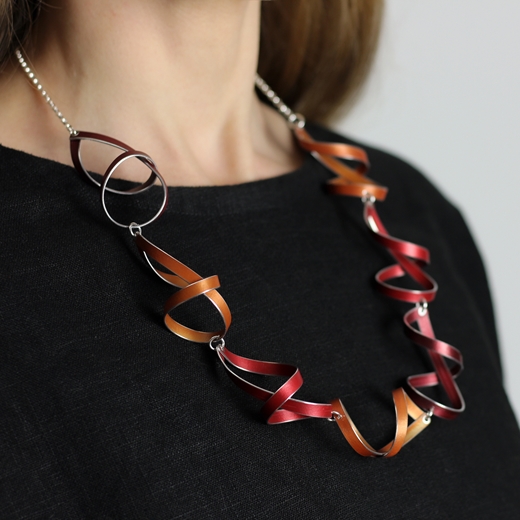 Red, orange and burgundy seven ribbon loop necklace worn