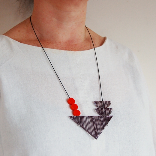 balance necklace triangle with orange on model