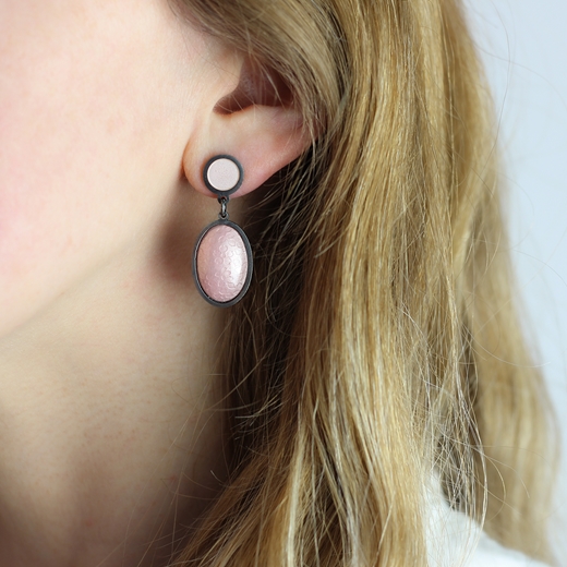 Pink oval earrings worn