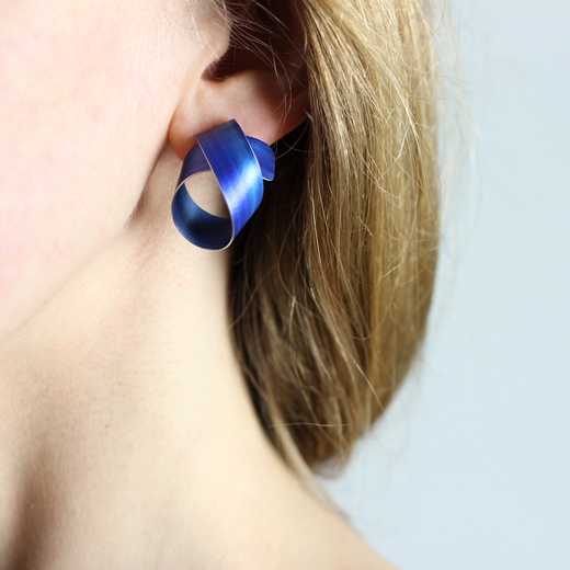 Royal blue wide coil stud earrings worn