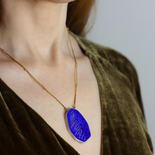 Blue and gold pendant worn