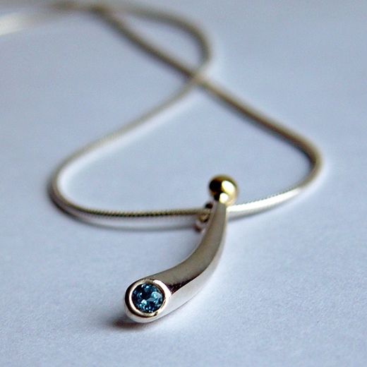 Small curved silver pendant with blue topaz & 18ct gold bead