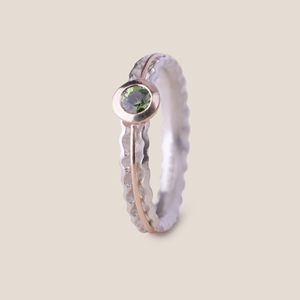 Embrace ring with green sapphire by Clara Breen
