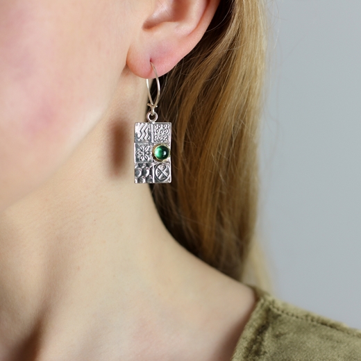 Asymmetrical earrings worn with Peridot