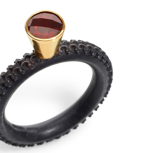 Detail of Round garnet ring in tall setting