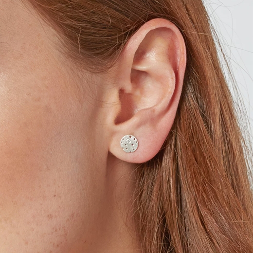 Silver and diamond earrings worn