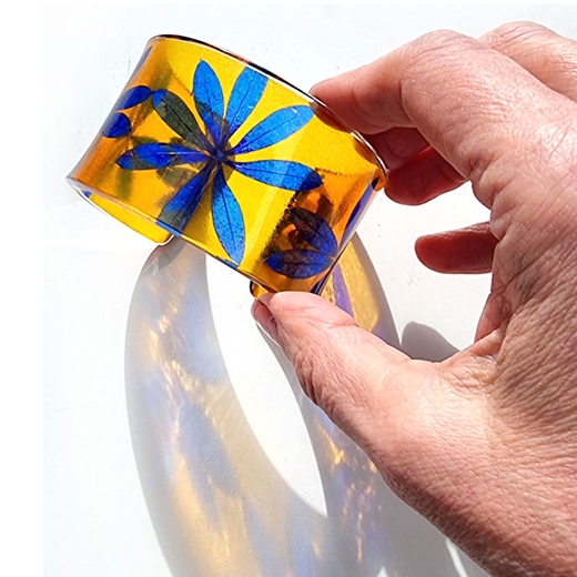 Tuemeric and yellow star leaf cuff on arm recycled plastic Sue Gregor with hand