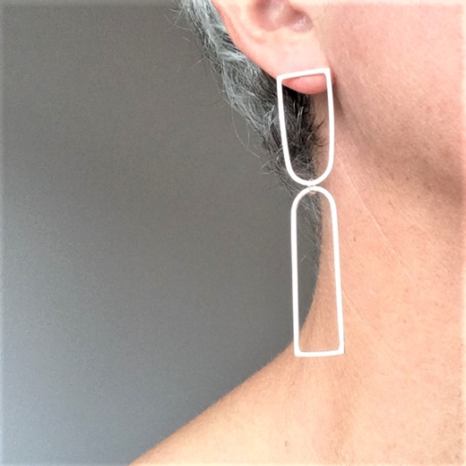 Two wire arch earrings on the ear